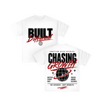 Two white short-sleeve graphic T-shirts shown on a plain white background, with the front and back views overlapping. The front has large white text reading 'BUILT' above red script text that appears to say 'Different.